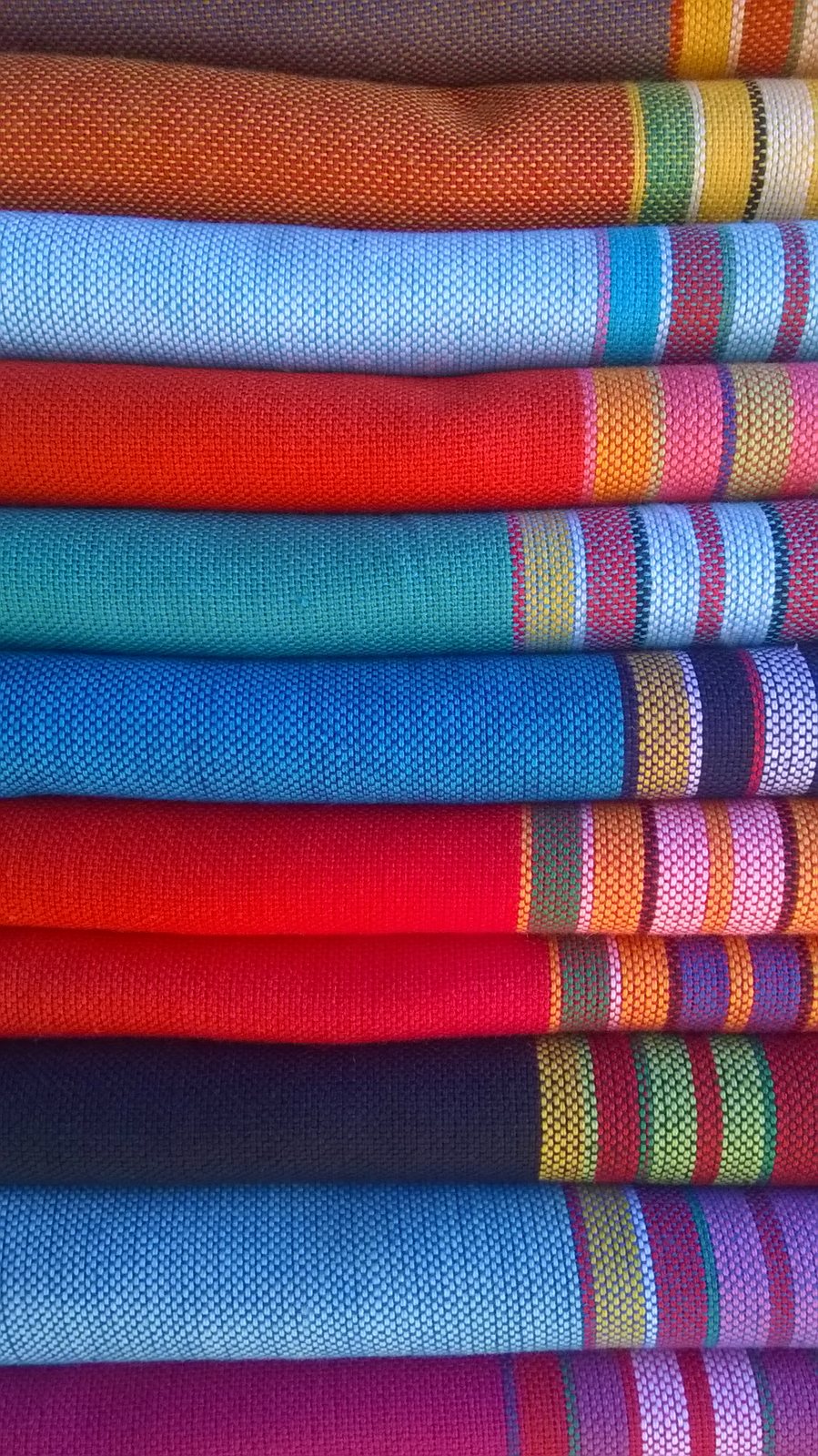 Piles de tissus kikoy aux rayures colorées au Maasai Market de Nairobi