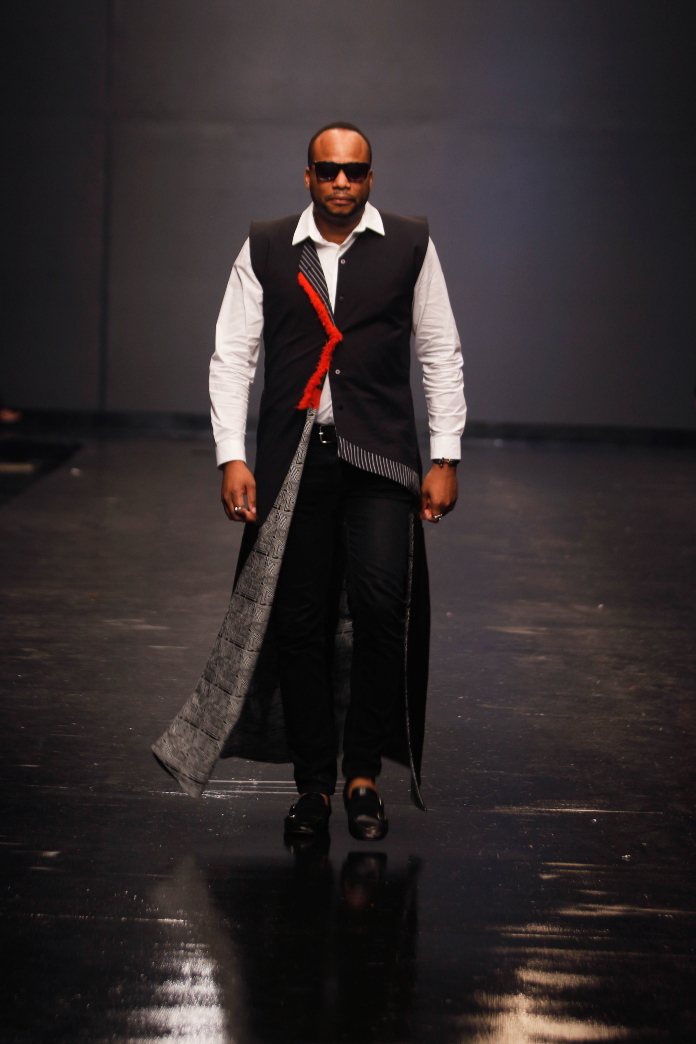 Un mannequin en long manteau défile sur le podium de la Lagos Fashion Week 2018